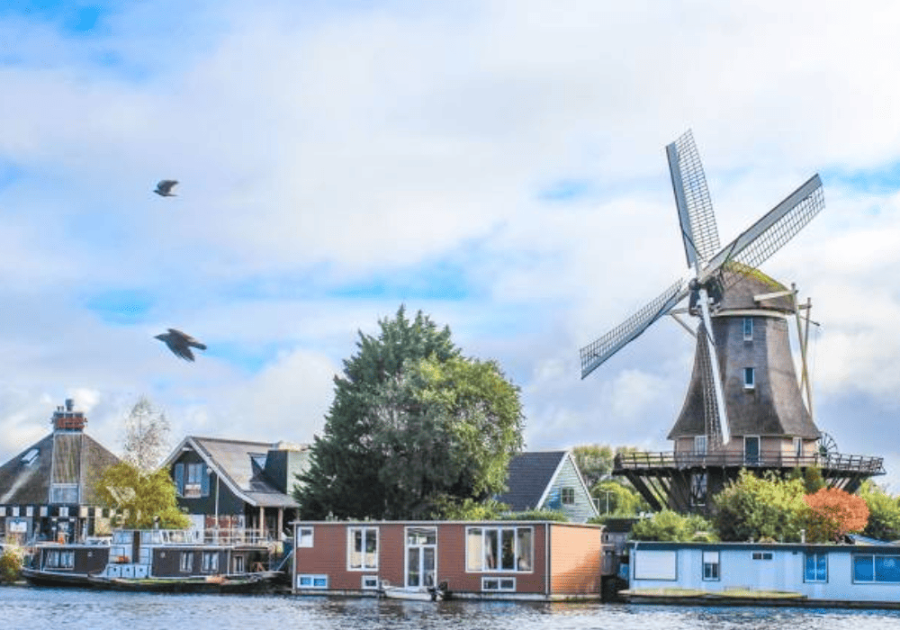 Traditional Dutch windmill near a waterfront.