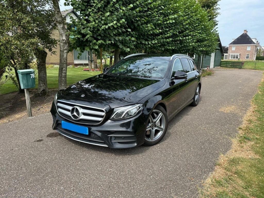 Black Mercedes station wagon parked outside.
